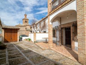 a courtyard of a building with a church in the background at Casa Dorrego Toledo in Cabañas de la Sagra