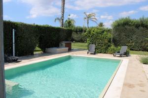a swimming pool with two chairs in a yard at S&S - Marino's Resort in Petrosino