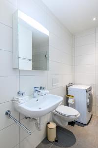 a white bathroom with a sink and a toilet at Casa Rheinblick - Apartment D in Basel +36 photos