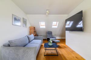 a living room with a couch and a tv at Casa Rheinblick - Apartment D in Basel
