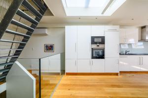 a kitchen with white cabinets and a skylight at Casa Rheinblick - Apartment D in Basel