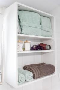 a white cabinet filled with towels in a bathroom at Lakeview Sunset Kastoria in Kastoria +8 photos