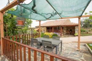 a patio with a table and chairs and a house at Casa do Dão in Oleiros