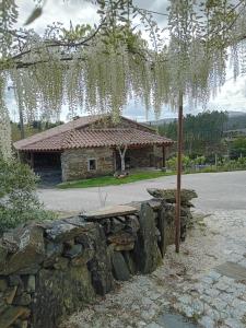 a stone bench in front of a stone building at Casa do Dão in Oleiros
