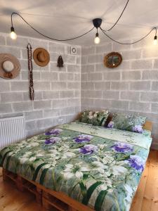 a bedroom with a bed with flowers on it at Guest house with sauna in Krčedin