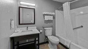 a bathroom with a sink and a toilet and a mirror at Chandigarh Hotel in Chandīgarh