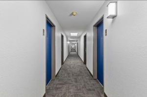 a hallway with blue doors and a long corridor at Chandigarh Hotel in Chandīgarh