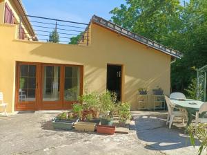 a house with potted plants in front of it at Iris Garden Cottage in Saint-Germain-en-Laye
