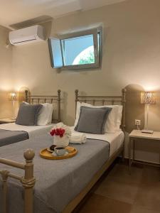 a bedroom with two beds with a tray with flowers on it at Portes Houses in Koufonisia
