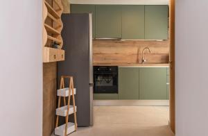 a kitchen with green cabinets and a ladder in the doorway at Little escape in episkopi-heraklion