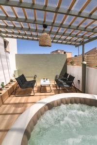 a patio with a pool and chairs and a pergola at Little escape in episkopi-heraklion