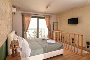 a bedroom with a bed and a balcony at Little escape in episkopi-heraklion