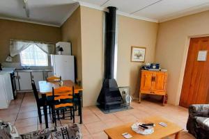 a living room with a fireplace and a table and a stove at Alpha Self-Catering in Sutherland +10 photos