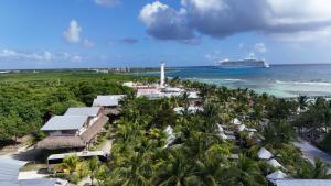 an aerial view of a resort with a cruise ship in the ocean at Eco Cabañas Bluekay in Mahahual