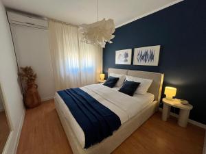 a bedroom with a large bed with blue walls at Apartments Tomislav in Novalja