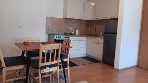 a kitchen with a table and a stove and a refrigerator at Una Relax Apartment - Naturally Cool - North-Facing - Near the River in Bosanska Krupa
