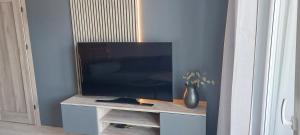 a flat screen tv sitting on a stand in a room at Apartament Podjasnogórski Loretańska in Częstochowa