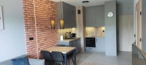 a kitchen with a table and chairs and a counter at Apartament Podjasnogórski Loretańska in Częstochowa