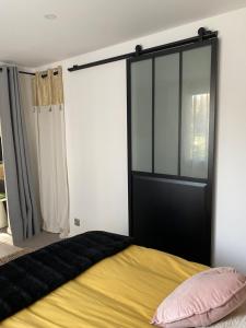a bedroom with a bed with a black door at Appartement avec espace jacuzzi et terrasse in Rians