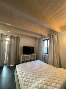 a bedroom with a bed and a flat screen tv at Casa Gloria in Zelbio