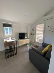 a living room with a couch and a television at Appartement avec espace jacuzzi et terrasse in Rians