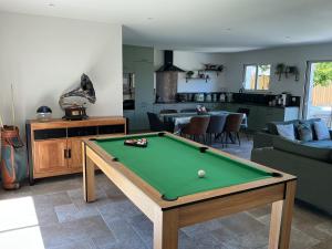 a living room with a pool table in it at Maison de vacances Helios in Seignosse