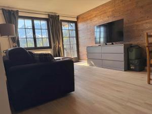 ein Wohnzimmer mit Sofa und Flachbildfernseher in der Unterkunft Champoussin A'part in Champoussin