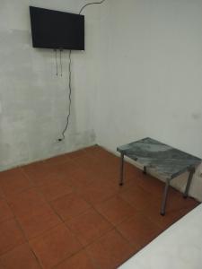 a room with a table and a tv on a wall at Dollar in Liberia