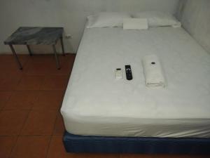 a white bed with a table on top of it at Dollar in Liberia
