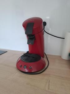 a red blender sitting on top of a wooden floor at LE 84 in Le Mans