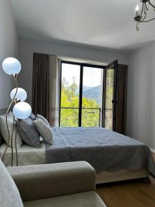 a bedroom with a bed and a large window at Luxury Residence Likani in Borjomi +129 photos