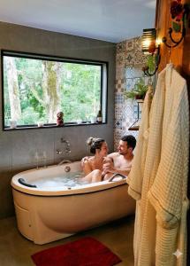a man and woman sitting in a bath tub at Chalé Temático em Pipa de Vinho - Parada da Pipa Chalés in Canela +86 photos