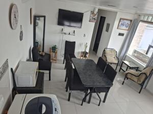 a living room with a table and chairs and a television at JAP in Río Gallegos
