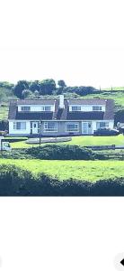 a large white building in a grassy field at Oceanview B&B in Ringville