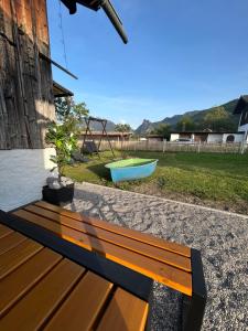 a wooden bench sitting next to a yard with a boat at Ferienhaus Luisl & Hilde in Unterammergau