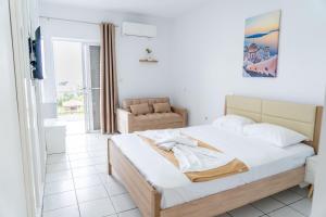 a bedroom with a bed and a chair and a window at Panagiota Lounge Sea View in Kanali