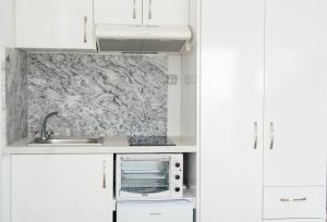 a white kitchen with a sink and a microwave at Panagiota Lounge Sea View in Kanali +21 photos