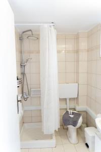 a white bathroom with a shower and a toilet at Panagiota Lounge Sea View in Kanali