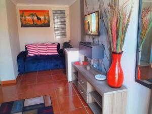 a living room with a red vase and a couch at Ecogreen on End in Northam