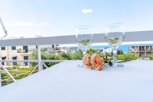 two glasses of wine on a table on a balcony at Panagiota Lounge Sea View in Kanali