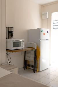 a kitchen with a table with a microwave and a refrigerator at Gosier séjour in Le Gosier