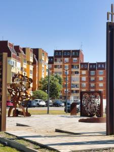 a park with a sculpture in a city with buildings at Apartman KATY - self check-in, besplatan parking, blizu centra in Vukovar