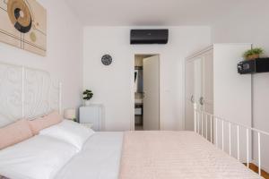 a white bedroom with a white bed and a staircase at Villa ELENA Room Old Town in Rogoznica +13 photos