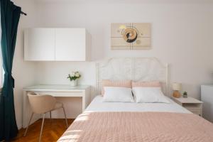 a white bedroom with a bed and a desk at Villa ELENA Room Old Town in Rogoznica