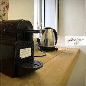 a black toaster sitting on a wooden table next to a window at Rebecca e Sofia Stone House affittacamere in Alberobello