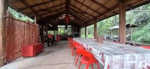 a long table and red chairs in a restaurant at Oasis 56 Aéroport Tontouta in La Tontouta