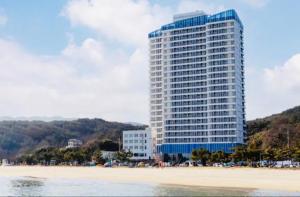 a tall building next to a beach with acean gmaxwell at 양양 죽도해변호텔 오션뷰스테이 일출뷰 바다뷰 힐링뷰 낭만뷰 넷플릭스완 in Saetchak