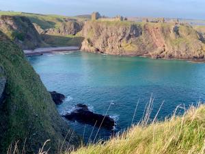 a view of a body of water with a beach at The Auld Bakehouse in Stonehaven