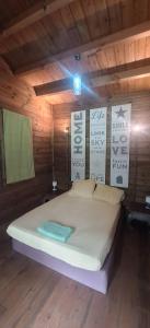 a bedroom with a large bed in a wooden room at Oasis 56 Aéroport Tontouta in La Tontouta