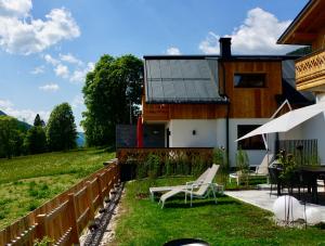 a house with a fence and a table and chairs at das korda - Ferienhaus & Sommercard in Ramsau am Dachstein +64 photos